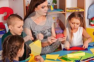 School children with scissors in kids hands cutting paper .