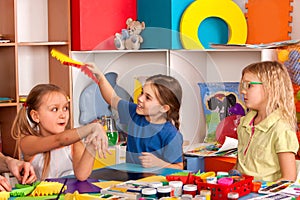 School children with scissors in kids hands cutting paper .