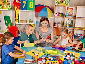 School children with scissors in kids hands cutting paper .