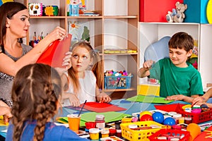 School children with scissors in kids hands cutting paper .