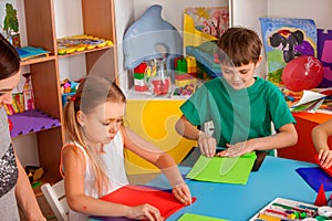 School children with scissors in kids hands cutting paper.