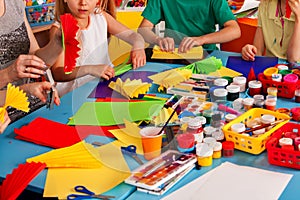 School children with scissors in kids hands cutting paper .