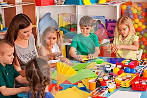 School children with scissors in kids hands cutting paper .