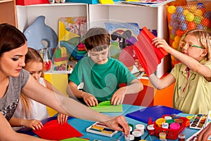 School children with scissors in kids hands cutting paper .