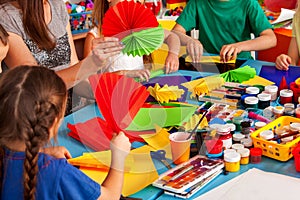 School children with scissors in kids hands cutting paper .