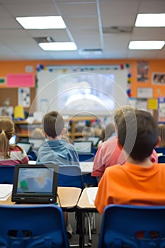 School children watching an educational film in a classroom with personal laptops.