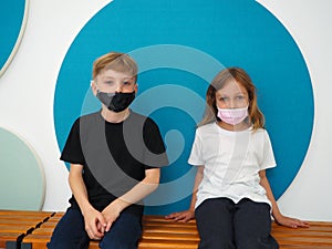 School children wearing face mask during corona virus and flu outbreak. Boy and girl going back to school after covid-19