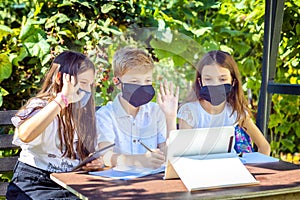 School children wearing protective face mask watching online education classes at home during corona virus lockdown outbreak