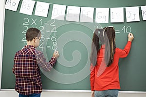 School children writing blackboard