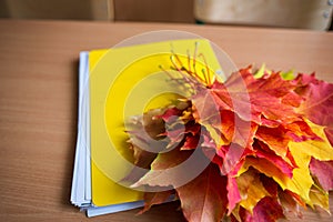 School classroom. notebook and bouquet of autumn maple leaves on the table. concept: back to school, teacher`s day