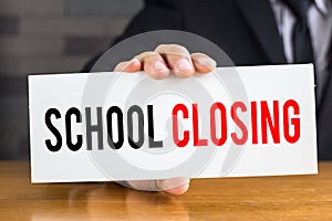 School closing, message on white card and hold by