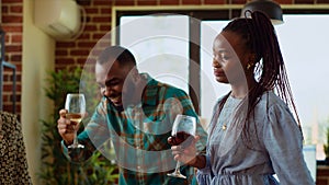 School colleagues organizing reunion party at home, enthusiastically dancing to disco music