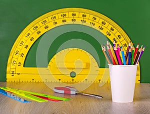 School concept colore pencil, ruler, scissors and yellow protractor photo