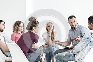 School counselor explaining anger management techniques to a group of teenagers photo