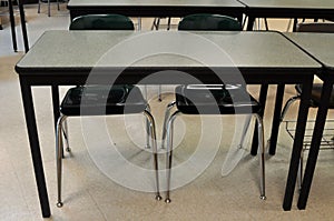 A School Desk with Two Empty Chairs