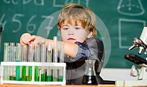 School education. Boy use microscope and test tubes in school classroom. Chemical analysis. Toddler genius baby. Science