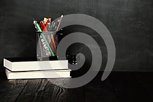 School and education concept.Copy space. Chalk board and old books. Pens and pencils in a bucket. Fountain pen and ink