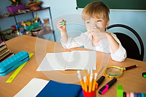School and education concept. Little children at school lesson. Happy student writing in notebook in school classroom