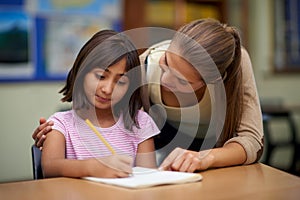 School, education or teaching with a student and teacher in a classroom together for writing or child development. Study