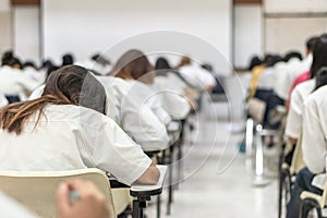 School exam student`s taking educational test, admission test, thinking hard, writing answer in university classroom, education