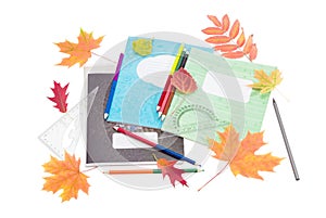 School exercise books, school supplies and yellow and red leaves