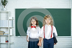 School friends. Two school kids, girl and boy holding hands going at school class in first class.