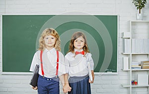 School friends. Two school kids, girl and boy holding hands going at school class in first class.