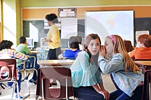 School, friends and whispering in classroom for secret, gossip or chatting during teaching lesson. Sneaky female