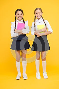 School friendship. Schoolgirls wear school uniform. Knowledge day. School day. Girl with copy books or workbooks. Study