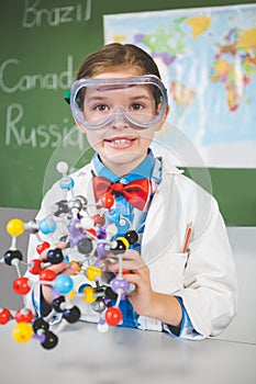 School girl assembling molecule model for science project in lab