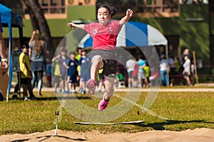 School girl athlete jump up high at school`s track and field lon