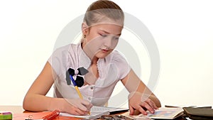 School girl doing her homework and writes essay on