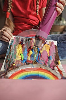 Girl draws rainbow with melted crayon pencils, she using blow dryer and wax stars to melt, art idea