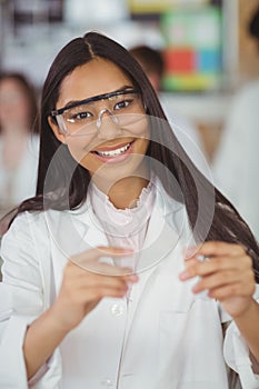 School girl experimenting with piece of glass in laboratory at school