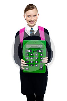 School girl holding large green calculator