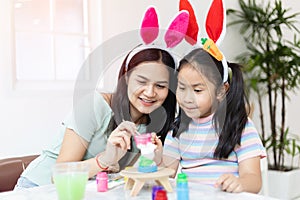 School girl with mother painting Plaster doll