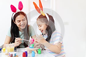 School girl with mother painting Plaster doll