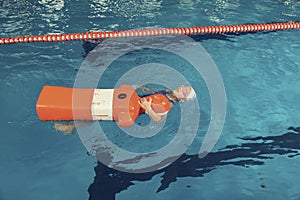 School Girl in a Pool Water Rescue Lesson Training Dummy
