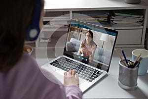 School girl student studying with online teacher on computer screen