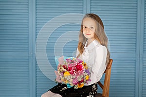 School girl in a uniform with autumn flowers