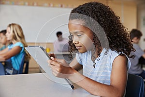 School girl using tablet in elementary school class close up