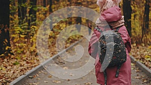 School girl walking in autumn park