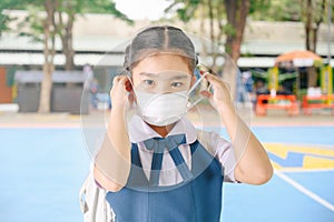 School Girl wearing mouth mask against air smog pollution in Bangkok city, Thailand