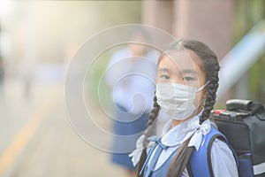 School Girl wearing mouth mask against air smog pollution in Bangkok city, Thailand