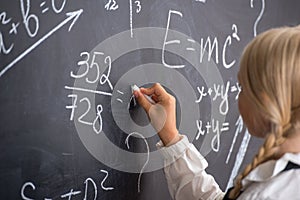 School girl writing on blackboard