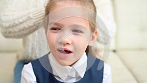 A school girl yawns while her mother combs her hair. early rises to school.