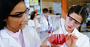 School girls experimenting with chemical in laboratory at school