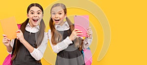 School girls friends. Read me story. Surprised kids hold books yellow background. Childrens literature. Portrait of