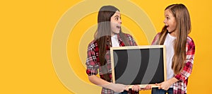 School girls friends. shosked kids in casual checkered hold school blackboard for copy space, promotion. Banner of