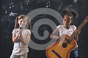 School girls singing and playing guitar in music class